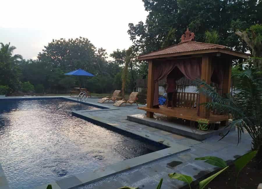 large backyard slate pool patio wood gazebo tile roof sun loungers