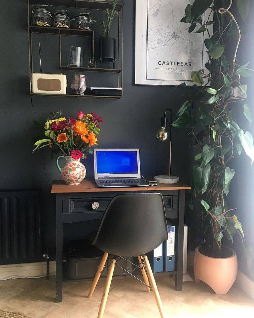 small elegant office desk with draws colorful floral teapot vase with flowers