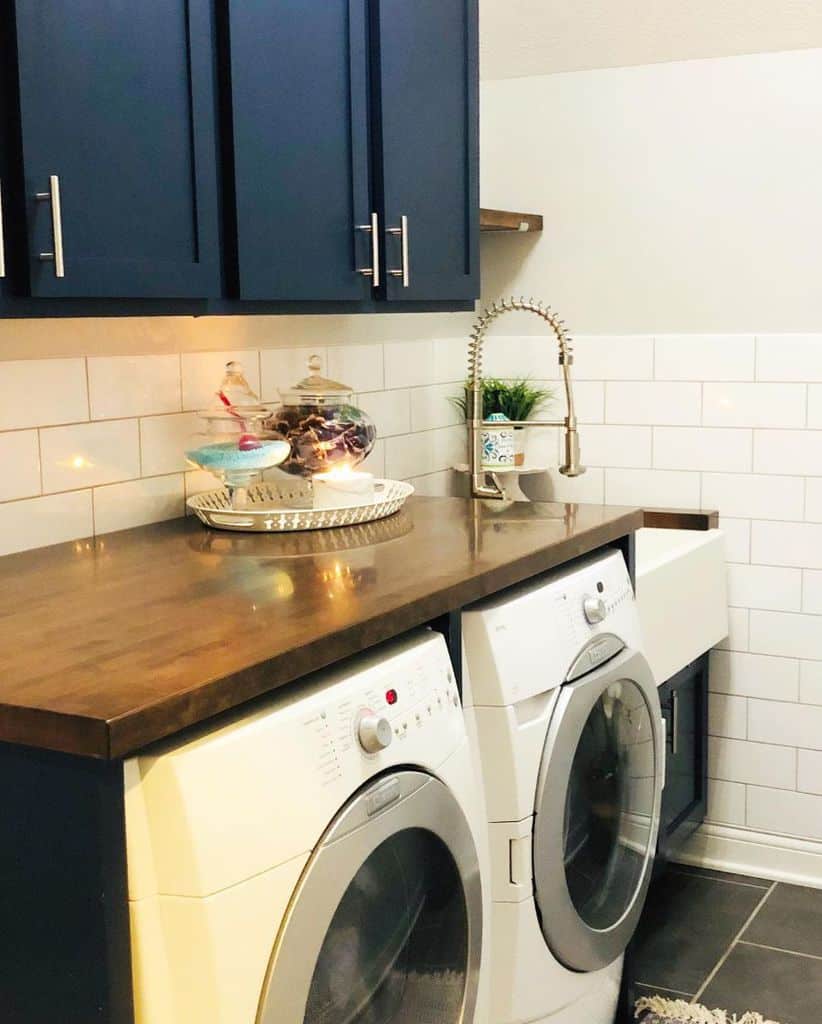 small laundry blue cabinets washer and dryer white wall tiles
