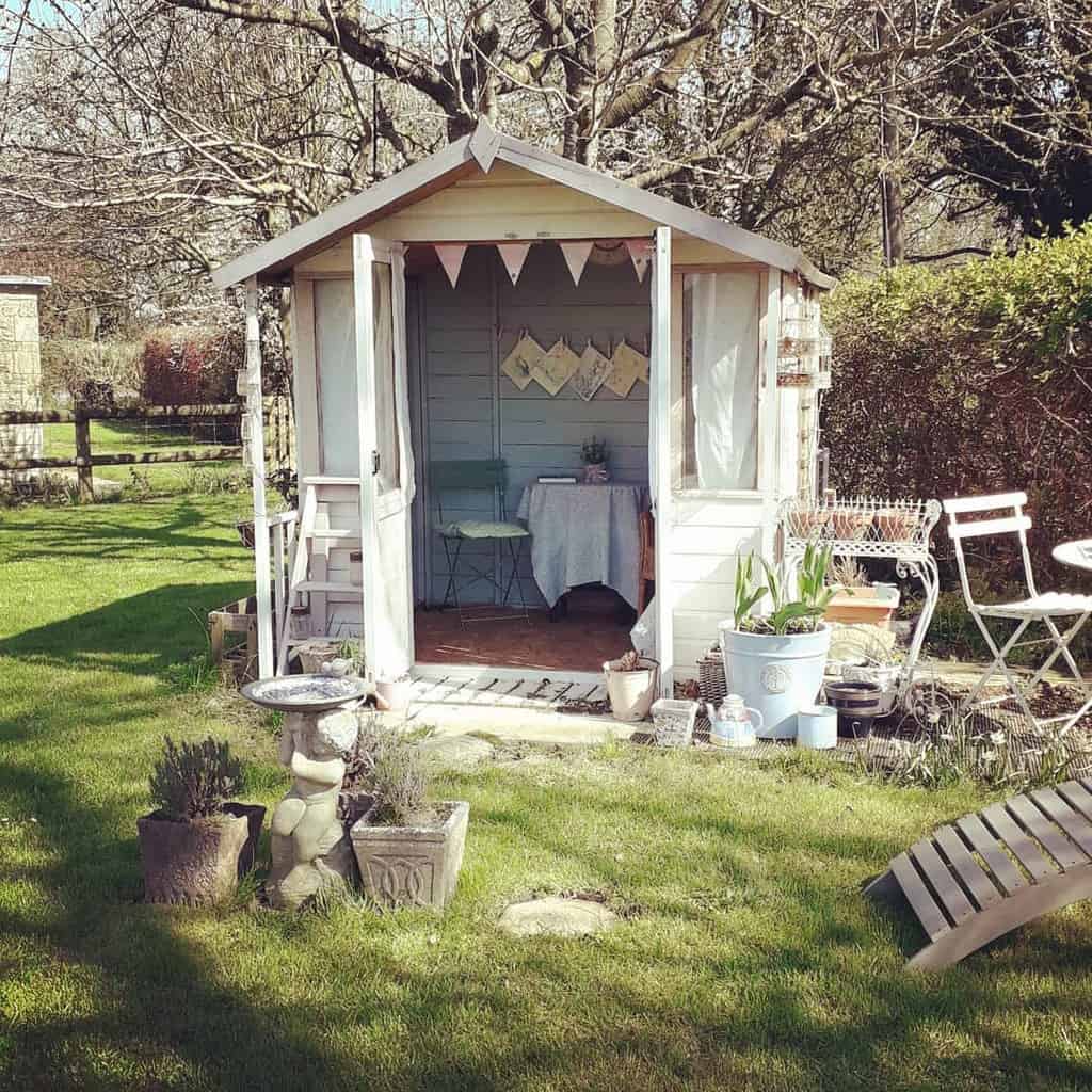 rustic white wood she shed in garden 