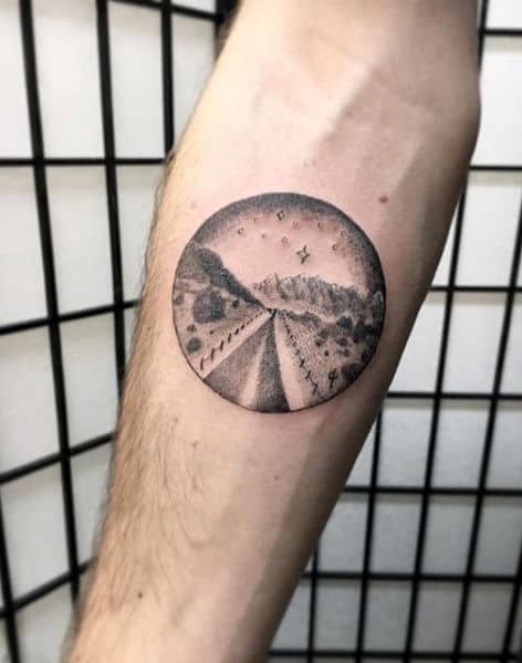 Small Simple Circle Desert Road With Cactus Plants Tattoo On Mans Inner Forearm