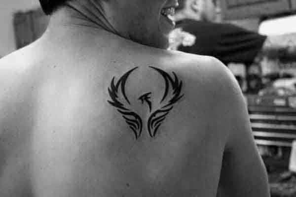 Small Simple Guys Tribal Phoenix Design Tattoo On Shoulder Blade