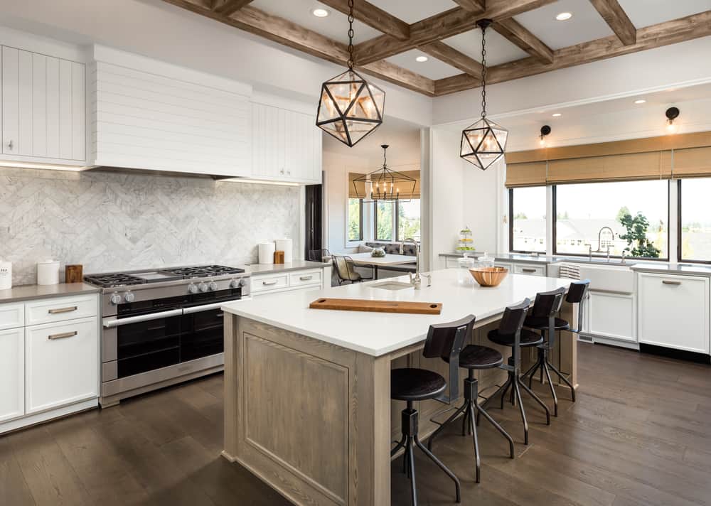 spacious luxury farmhouse kitchen white marble countertop pendant lighting black stools 