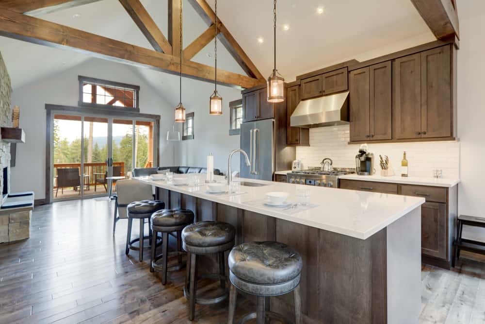 large farmhouse kitchen high ceilings white countertop hardwood floors