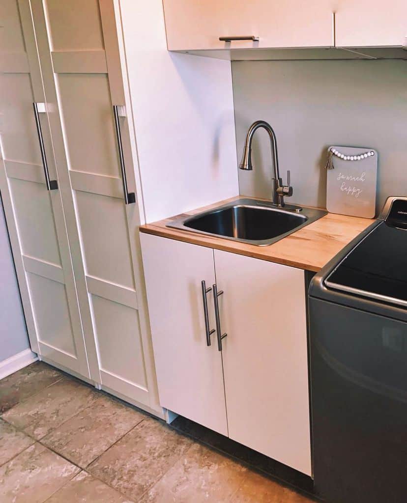 white cabinet laundry with stainless steel sink