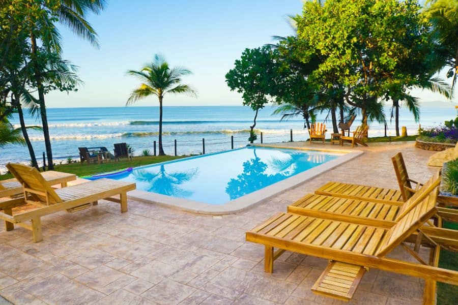 stamped concrete pool deck with wood sun loungers 