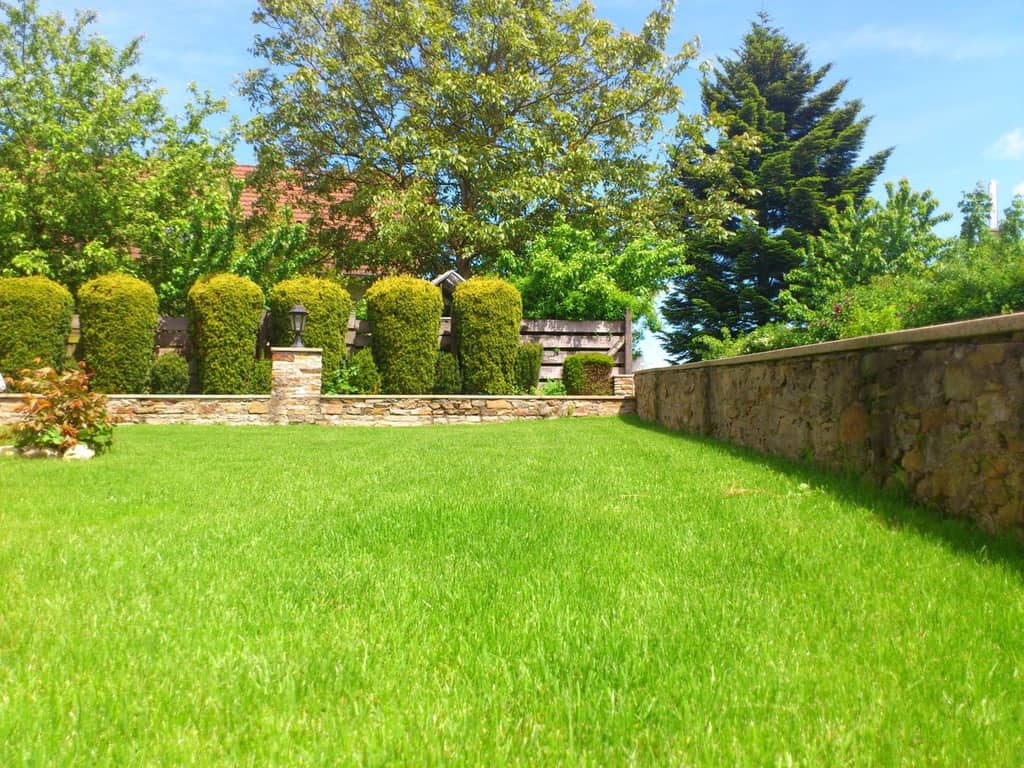 large grass lawn stone wall 