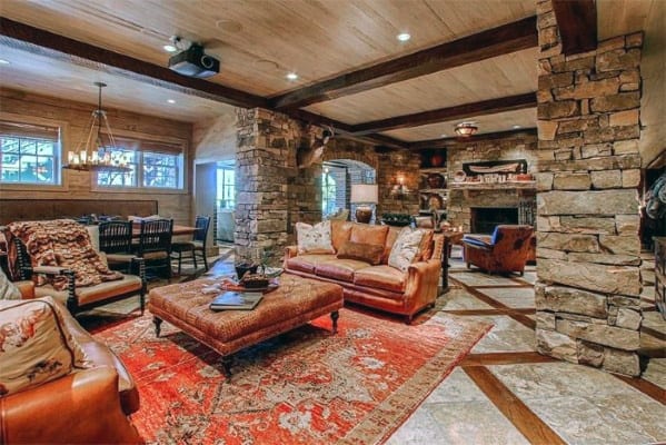 rustic stone basement red pattern rug leather couch