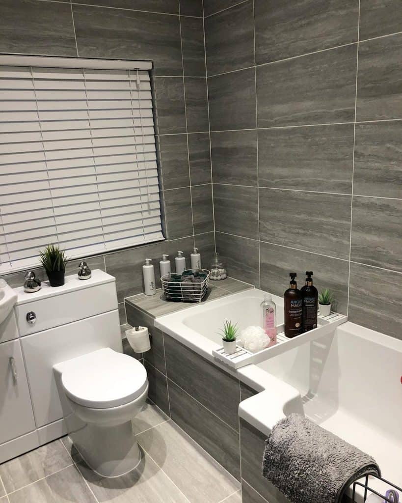 gray slate tile bathroom with tub and toilet