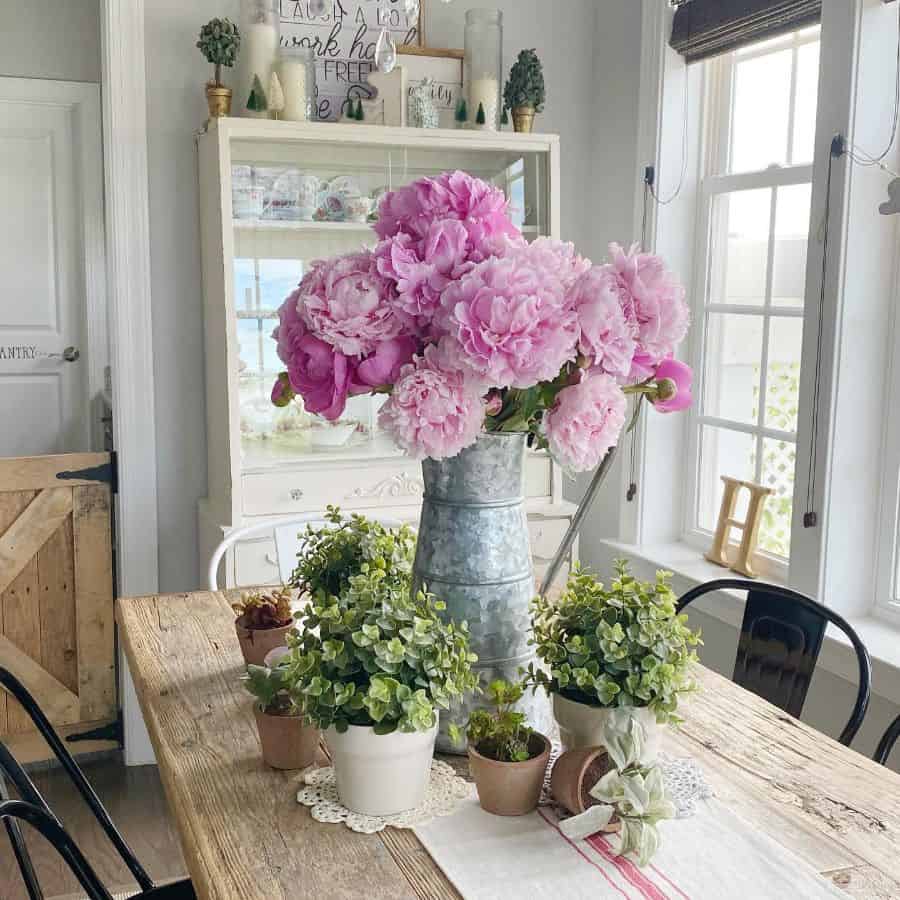 modern farmhouse dining room with rustic wood table and flowers 