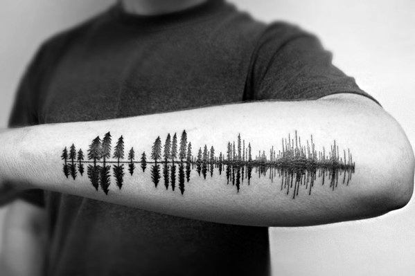 Fine line pine tree tattoo on the inner forearm