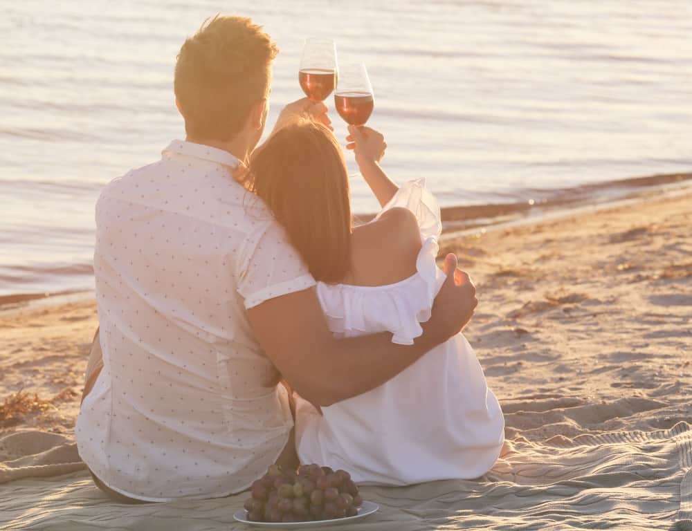 sweet couple with wine dating at the beach