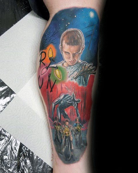 Tattoo inspired by *Stranger Things*, featuring Eleven using her powers, the Demogorgon, kids on bikes, and Christmas lights spelling "RUN" for a dramatic design.
