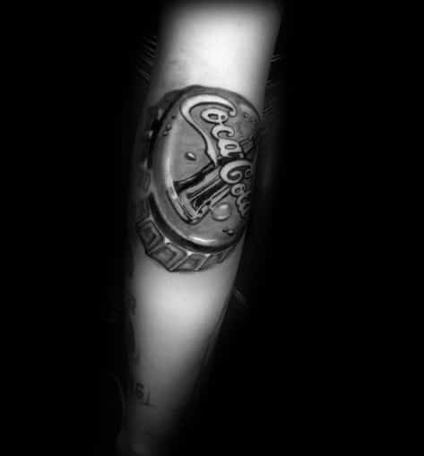 Hyper-realistic black and grey Coca-Cola bottle cap tattoo with intricate shading, highlights, and a 3D effect for a lifelike metallic look.