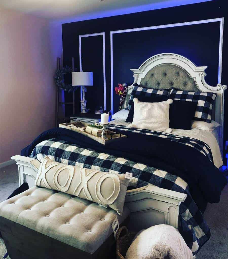 ornate white bed in bedroom with black accent wall