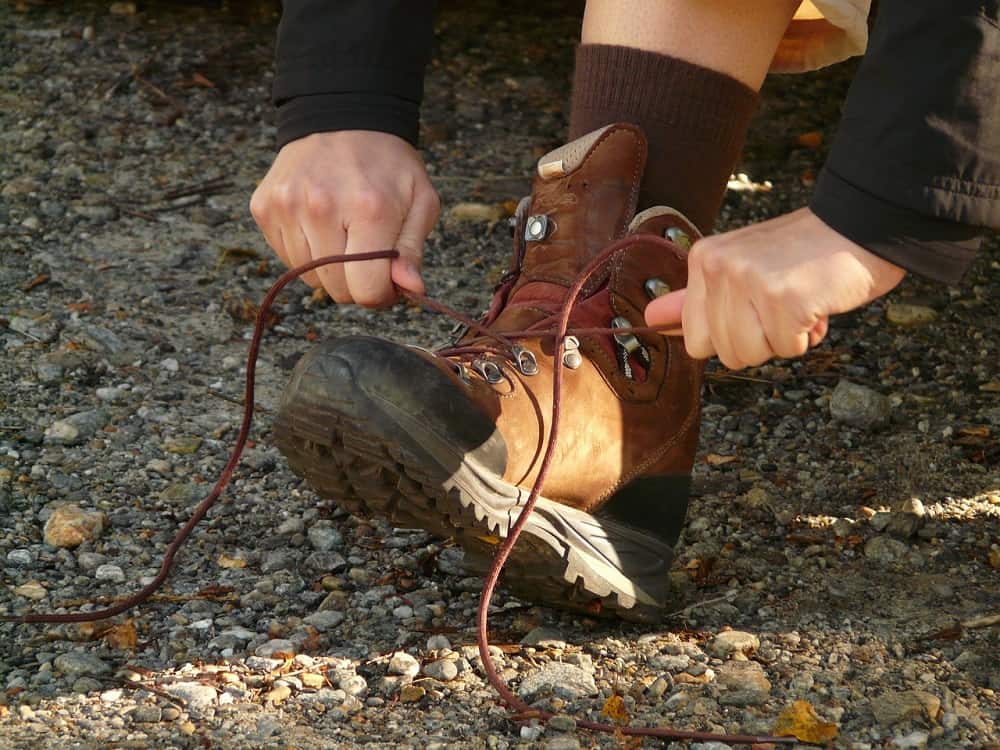 man tie shoe lace during hiking on trail