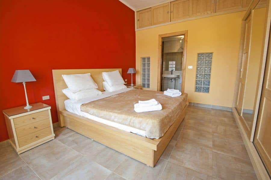 neutral bedroom red feature wall tiled floors