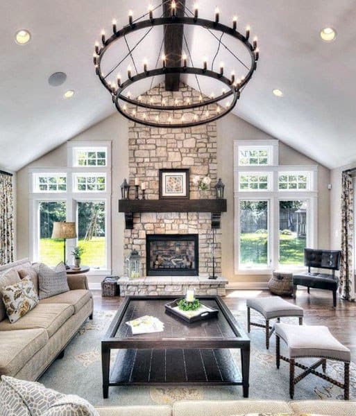 rustic living room with stone fireplace and candle chandeliers