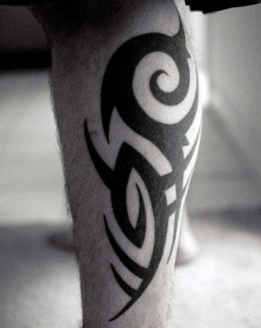 Traditional Leg Tribal Tattoo On Male With Black Ink