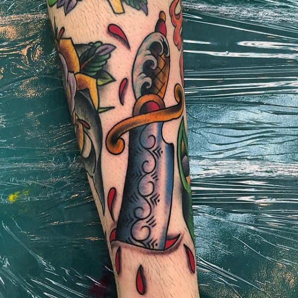 traditional-tattoo-of-knife-slicing-through-skin-guys-forearms