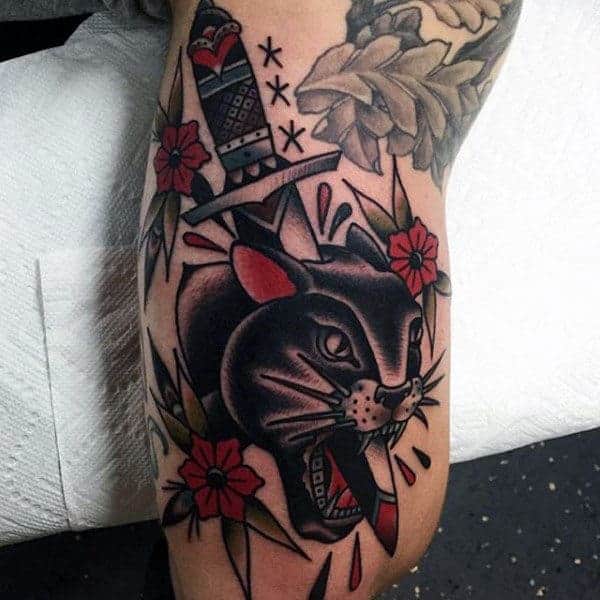 traditional-tattoo-of-knife-through-a-dark-feline-men-forearms