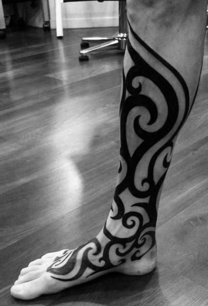 Traditional Tribal Mens Leg And Foot Tattoo With Black Ink