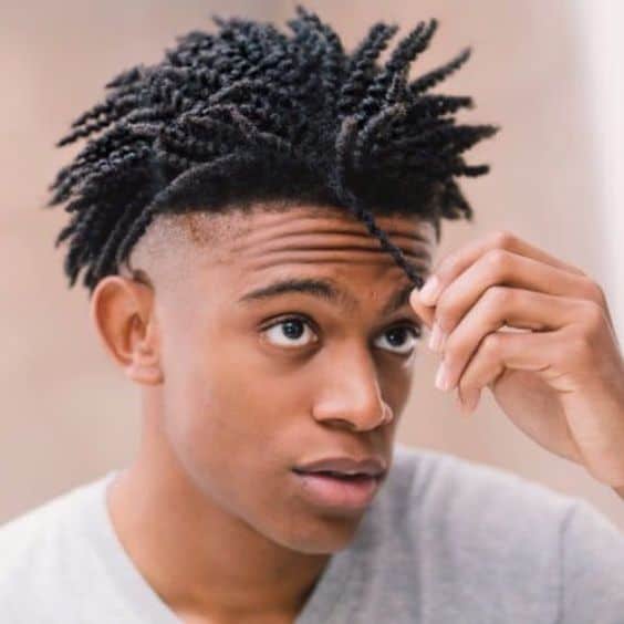 A black man wearing a twist out hair on top paired with a clean shaved low undercut