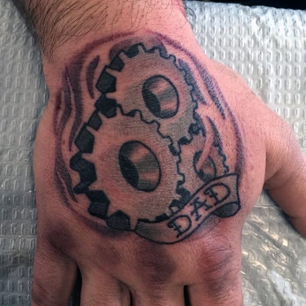 Two Rounded Gears And Dad Tattoos On Male Hands
