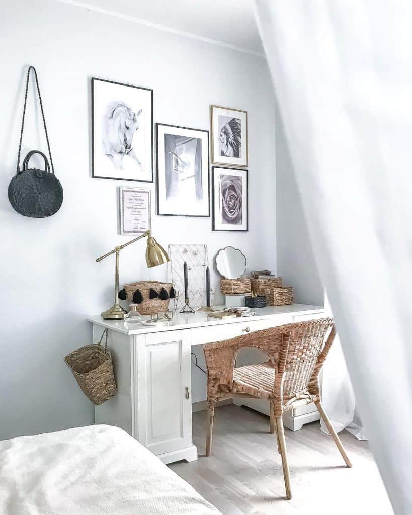 White vanity desk with wicker chair, wall art, and decorative storage baskets.