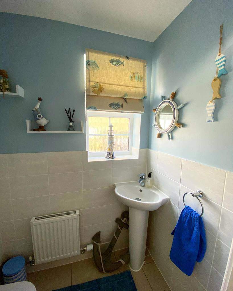 white tile and blue wall bathroom with corner sink 