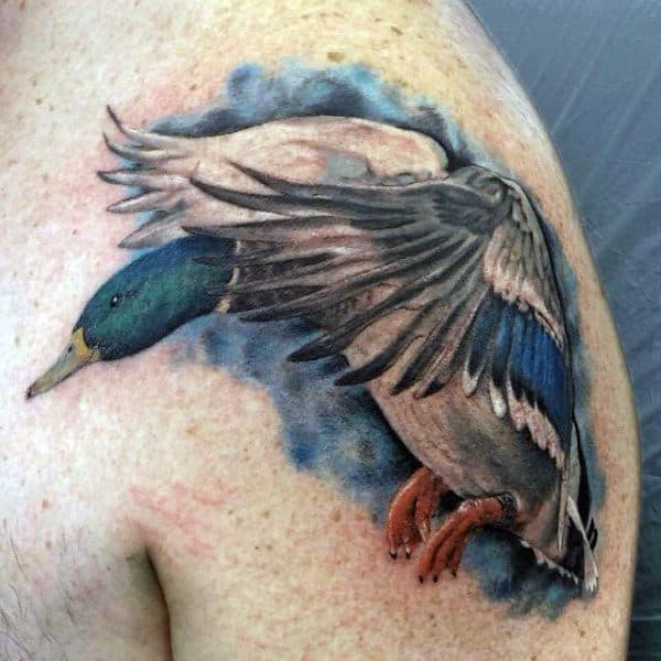 Watercolor Background Duck Flying Tattoo On Guys Shoulder