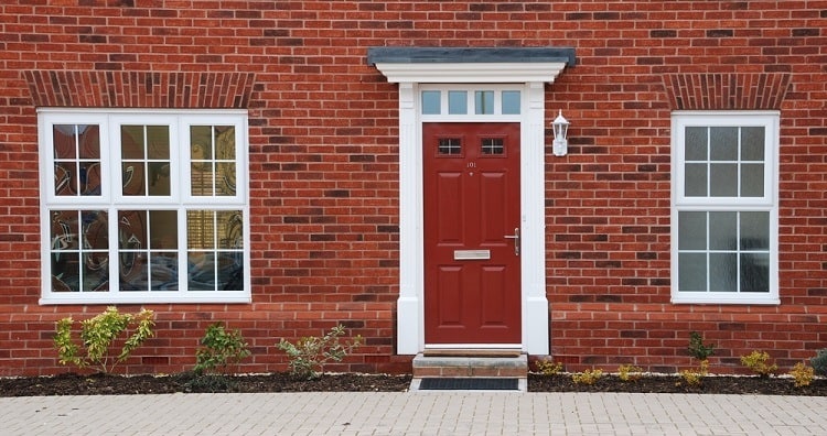 white exterior window trim brick house maroon door 