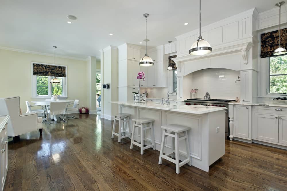 spacious farmhouse kitchen white cabinets and stools vinyl wood flooring 