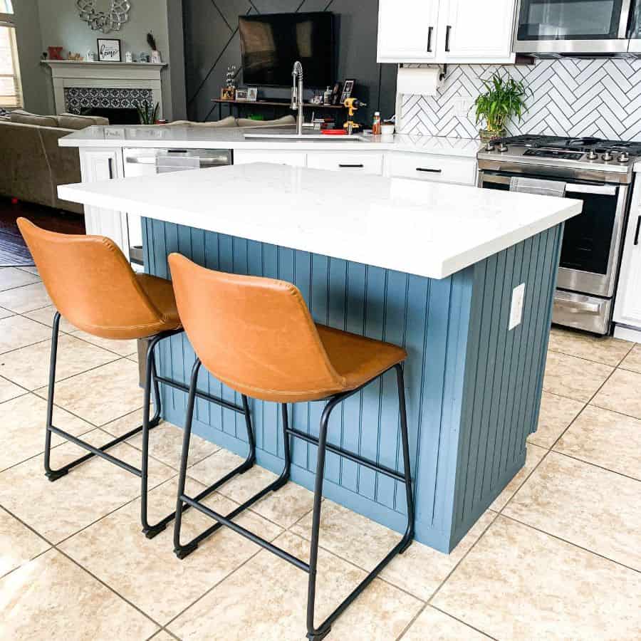 blue island bench kitchen white countertop two tan chairs 