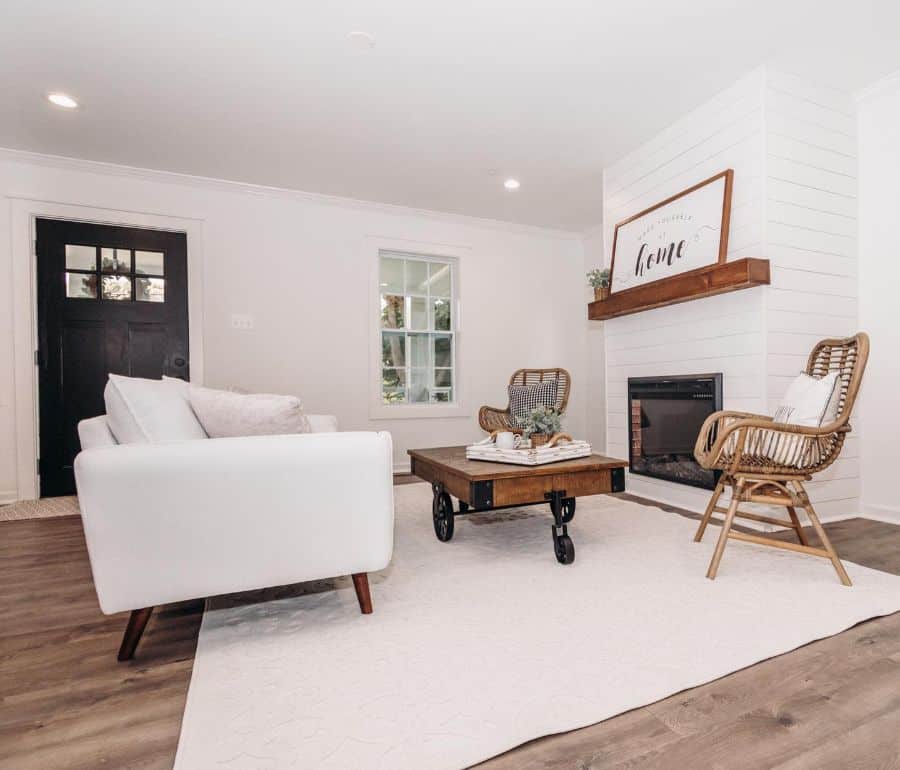 simple living room shiplap wall fireplace white sofa wood table with wheels black front door