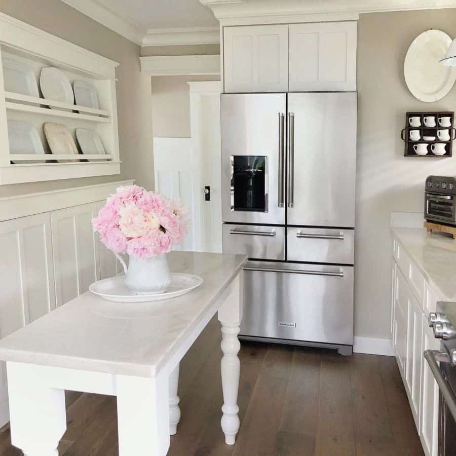 white small kitchen island with silver fridge 