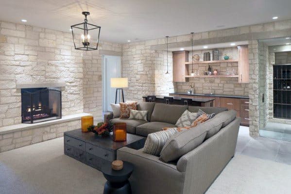 white stone luxury basement fireplace gray couch