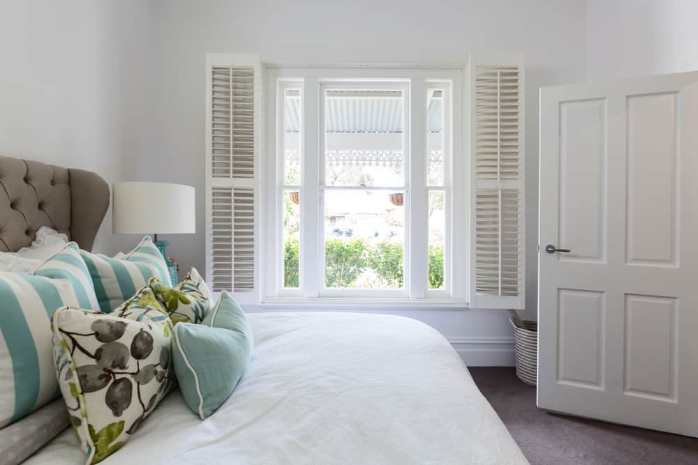 white bedroom with shutters gray headboard 