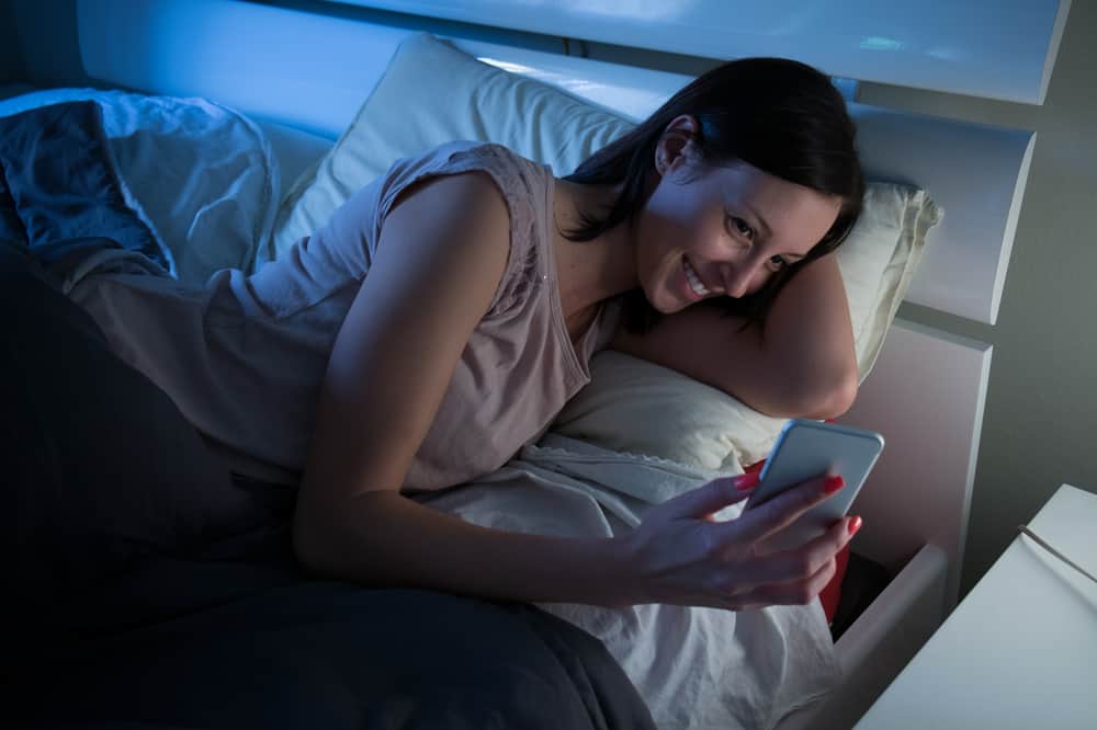 woman in bed with mobile phone