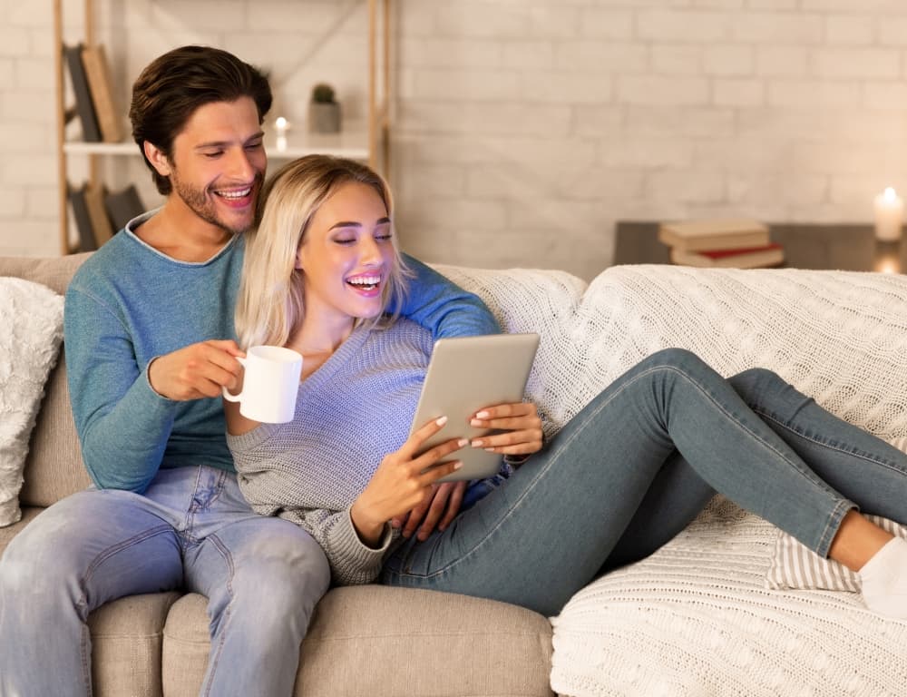 woman using tablet while man drinking coffee