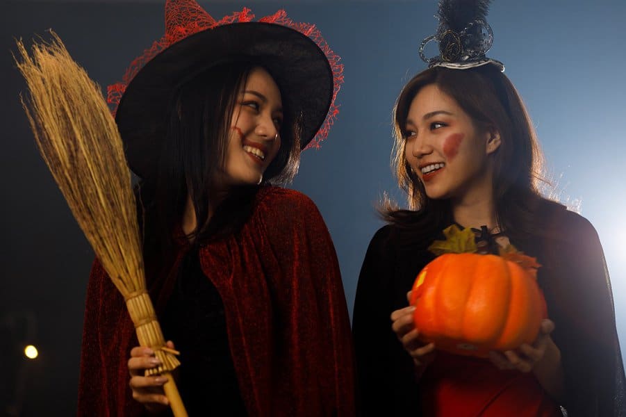 women smiling traditional trick and treat party at night