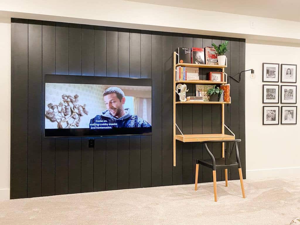 basement living room with desk and tv