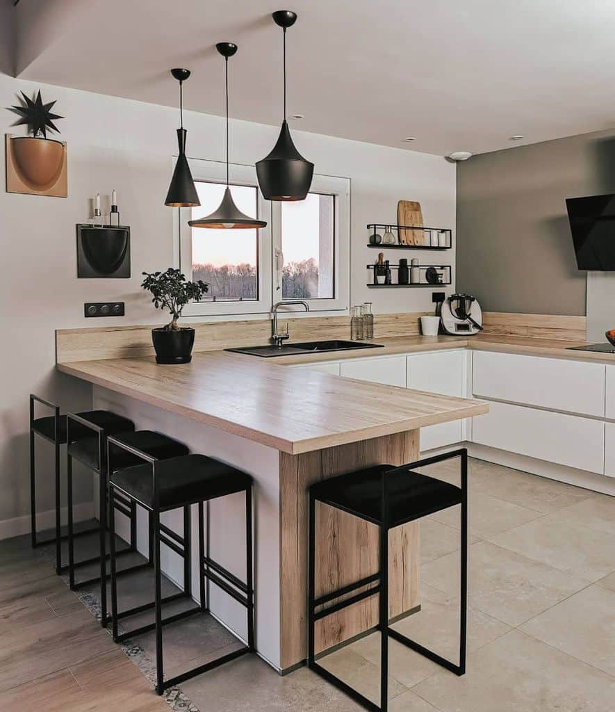 modern kitchen with white cabinets four black chairs and composite wood countertop 